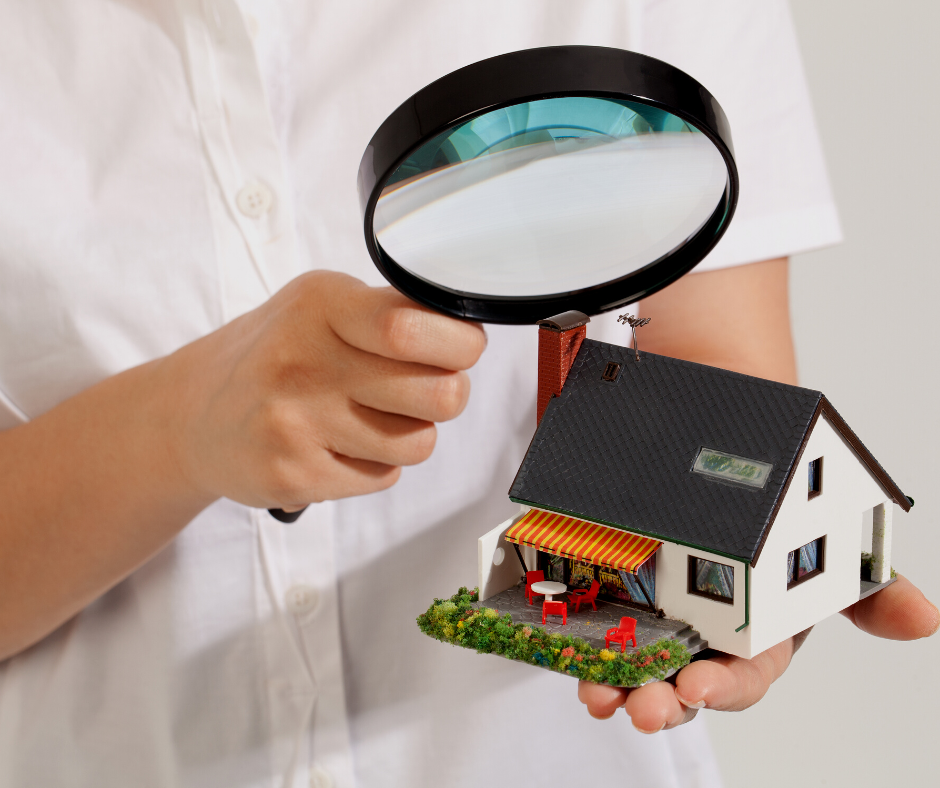 person inspecting the exterior of the home for painting